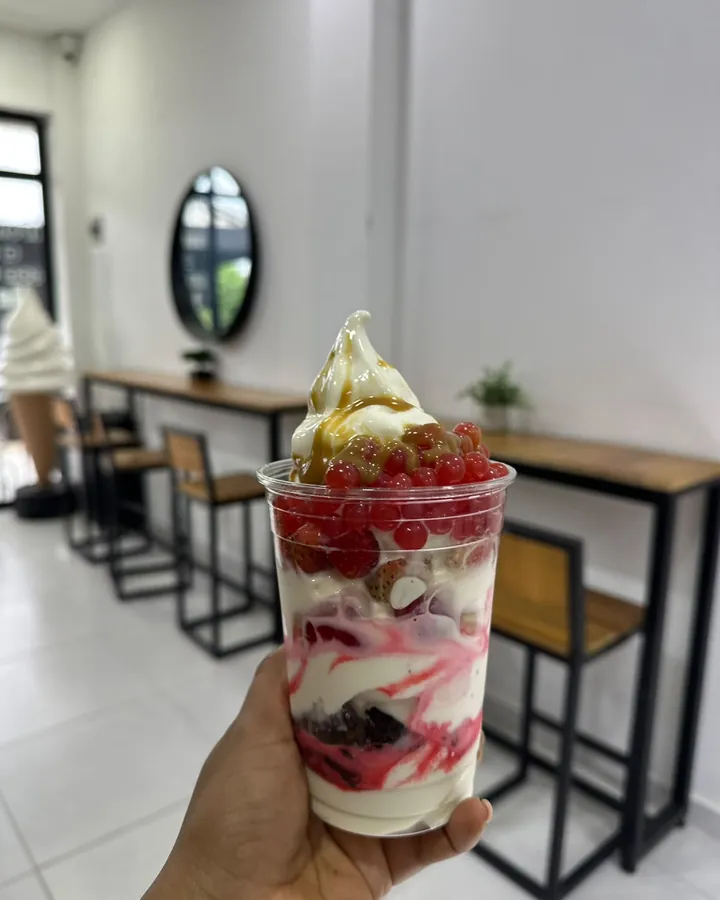 Vaso con helado, perlas explosivas y salsa de fresa