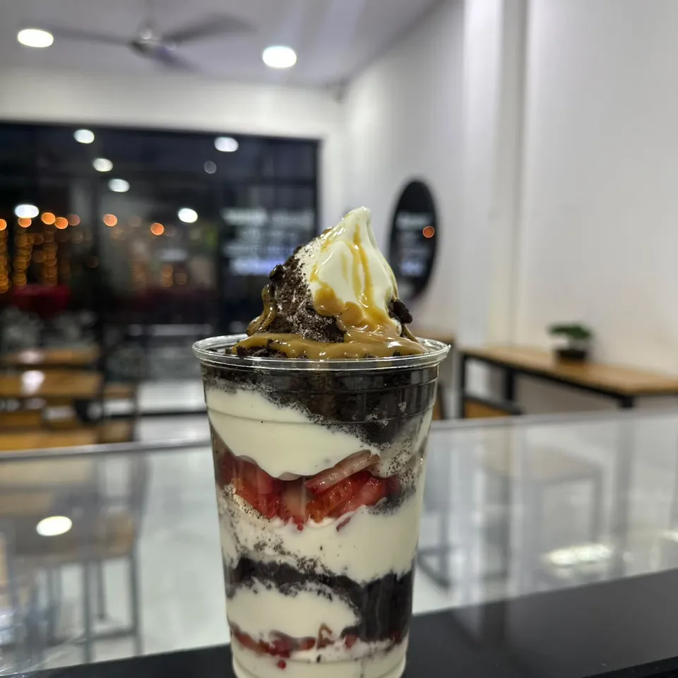 Vaso de helado con Oreo, fresa y arequipe sobre el mostrador del local de Maná