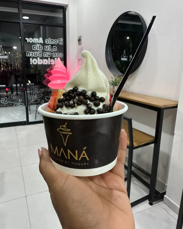 Vaso negro con el logo dorado de Maná, helado y perlas